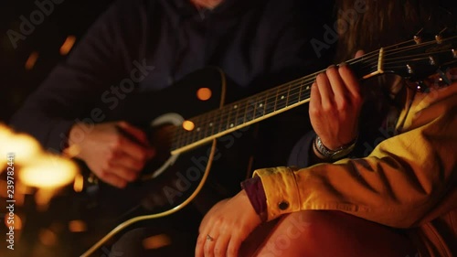 Playing guitar at a campfire