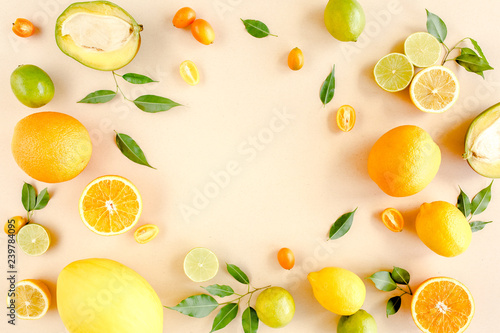 Frame made of summer tropical fruits: orange, lemon, lime, mango on yellow background. Food concept. flat lay, top view