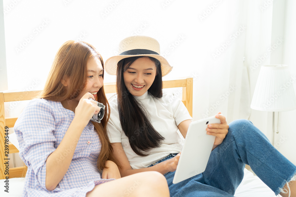 Young asian happy woman planning for travel in bed room .Check-in online for booking her flight trip. Young asian happy woman planning for travel in bed room .Check-in online for booking her flight trip.