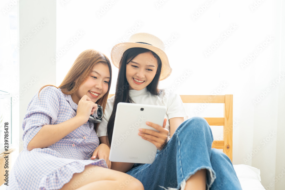 Young asian happy woman planning for travel in bed room .Check-in online for booking her flight trip. Young asian happy woman planning for travel in bed room .Check-in online for booking her flight trip.