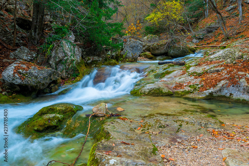 Beautiful landscape of a mountain river among large stones in the mountains in autumn