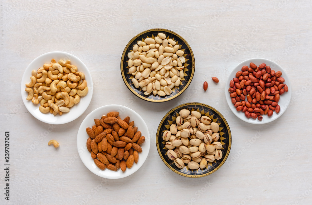 Corner border of fresh nuts in bowls Corner border of fresh nuts in bowls
