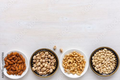 Corner border of fresh nuts in individual bowls