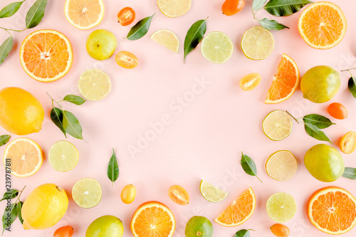 Frame made of summer tropical fruits  orange  lemon  lime  mango on pink background. Food concept. flat lay  top view