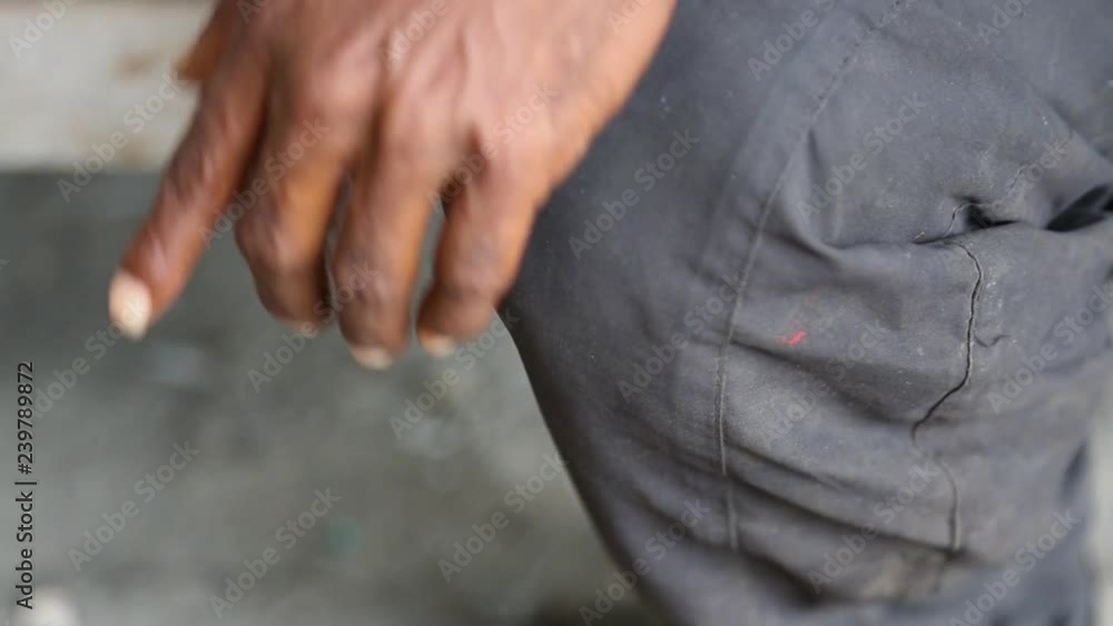 A close up shot mans hand by his side shaking slightly A close up shot mans hand by his side shaking slightly