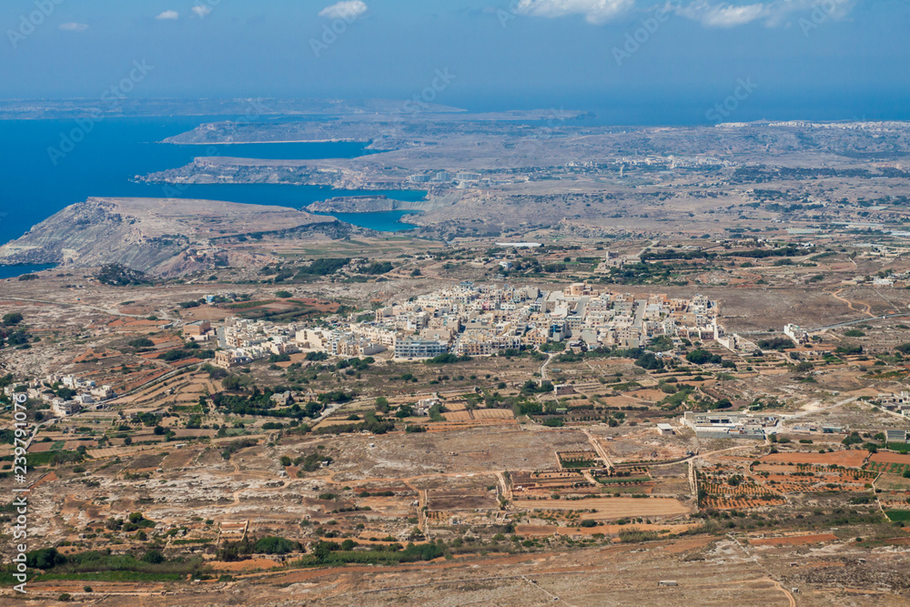 Aerial view of L-Imgarr (Mgarr, Mġarr, Mgiarro) town, Northern region, Malta island. Rich farmland and vineyards around. Panoramic photo of Malta from above toward north-west and Gozo island.