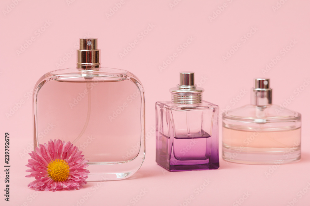 Women perfumes with flower on a pink background. Women perfumes with flower on a pink background.