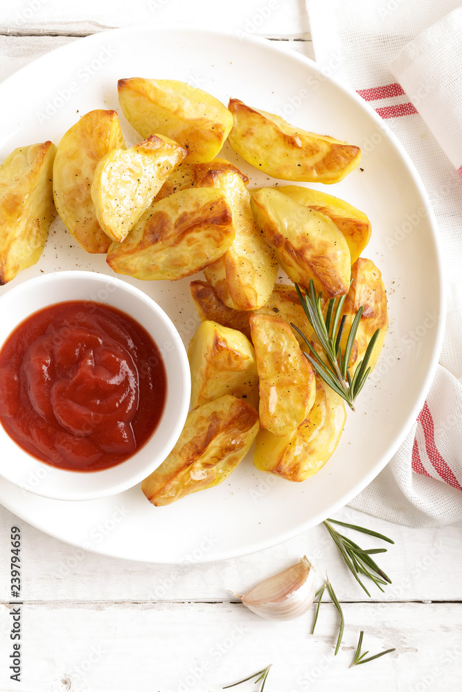 Potato baked and tomato ketchup on white plate, wooden background, top view Potato baked and tomato ketchup on white plate, wooden background, top view