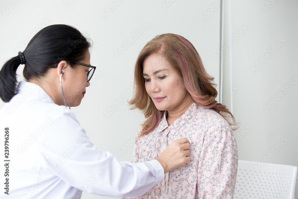 Doctor examining a woman in a hospital. Stethoscope doctor. Close Up. Asian people.