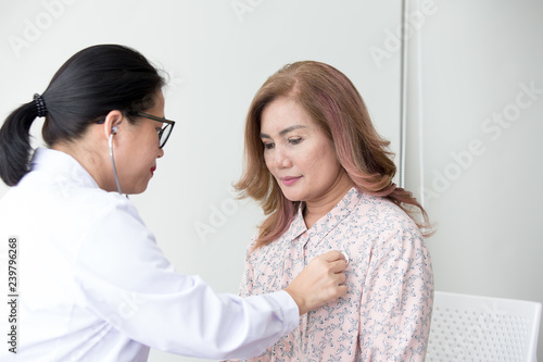 Doctor examining a woman in a hospital. Stethoscope doctor. Close Up. Asian people.
