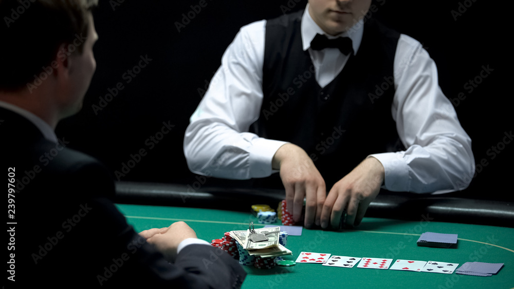 Casino croupier matching bet of player going all-in, betting all money and keys Casino croupier matching bet of player going all-in, betting all money and keys