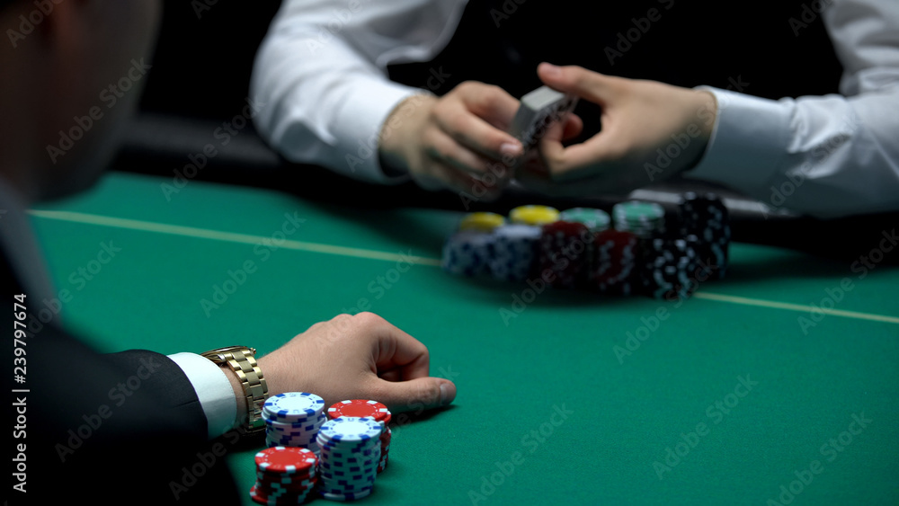Croupier ready to deal cards for businessman playing poker at casino, gambling Croupier ready to deal cards for businessman playing poker at casino, gambling