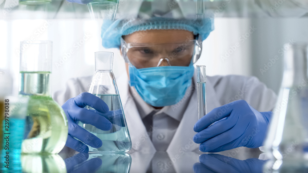 Lab assistant in protective suit waiting for reaction and toxic emissions, test Lab assistant in protective suit waiting for reaction and toxic emissions, test