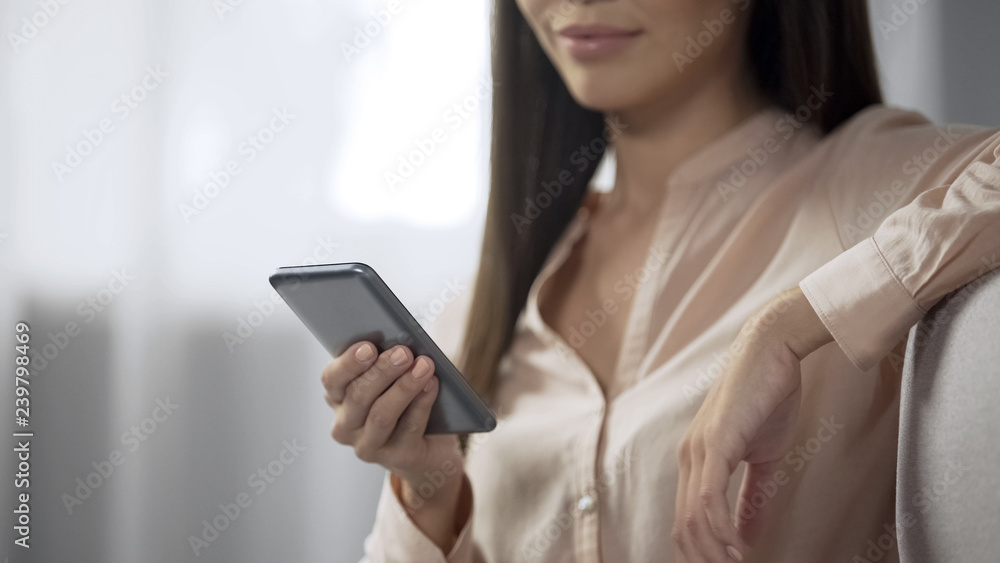 Charming girl booking hotel room with a smartphone, user-friendly reserving