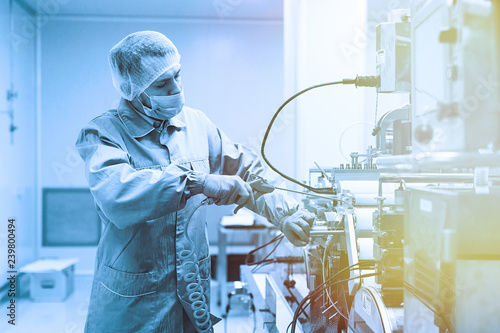 plant picture, factory worker is fixing machine, steel machines. Blue tone. Blue tint photo