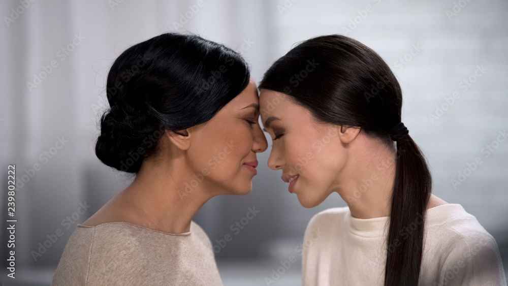 Mother feeling happiness for her daughter, expressing love, touching forehead Mother feeling happiness for her daughter, expressing love, touching forehead