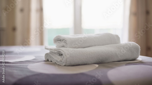 Hotel room with clean towels on fresh bed linen, accommodation service quality
