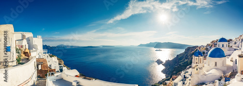 Churches in Oia, Santorini island in Greece, on a sunny day. Panorama view.