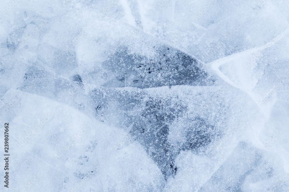 Close-up of snow on cracked and thin layers of ice in the winter. Simple and minimal full frame abstract background. Copy space.