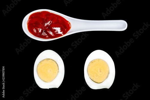 Hard boiled egg with spoons with ketchup