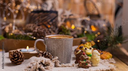 Fragrant coffee, chocolates in the form of Christmas figures. Cookies and hot drink for the holiday. Cozy atmosphere, candles decor. free space for text. Banner,