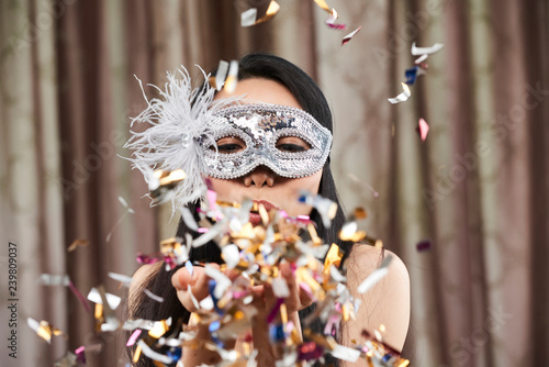 Woman blowing out confetti