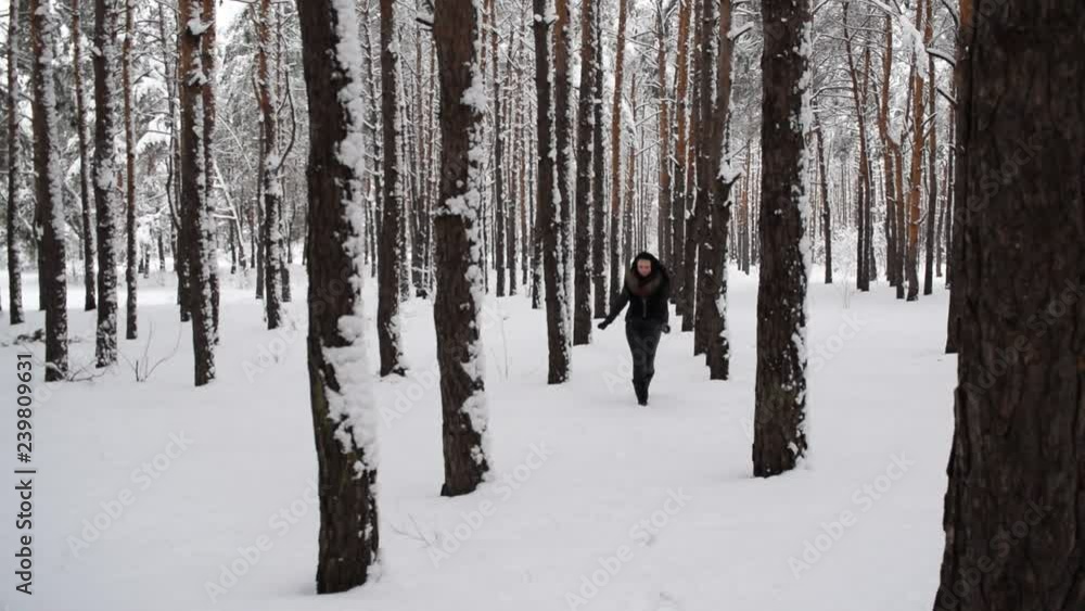 Young girl in black walks in winter forest. Young girl in black walks in winter forest.