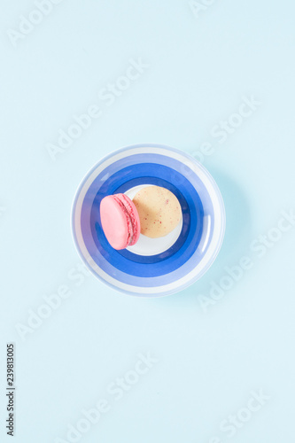 Two color macarons on a blue plate.
