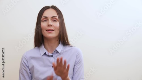 A brunette looks into the camera smiling, makes dancing movements playfully and pretends whistling