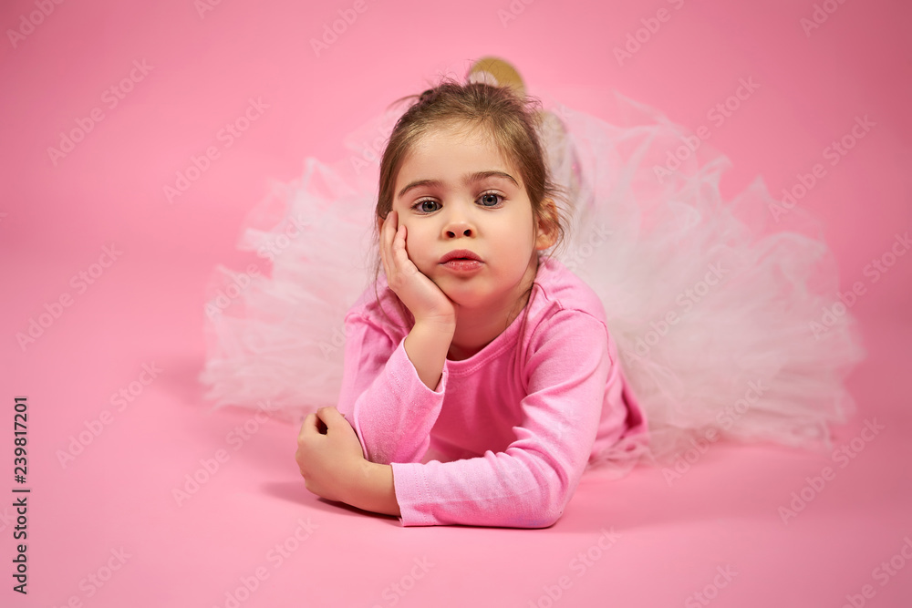 portrait of a cute little girl in white tulle skirt on a pink background portrait of a cute little girl in white tulle skirt on a pink background
