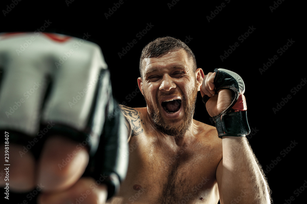 MMA. professional boxer boxing isolated on black studio background. fit muscular caucasian athlete fighting. Sport, competition, excitement and human emotions concept