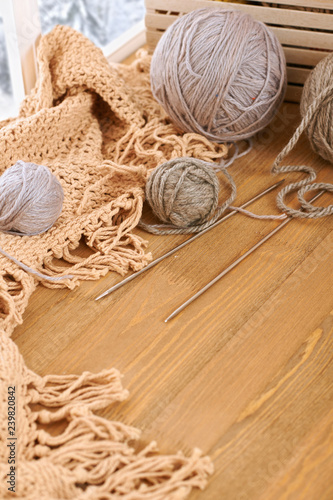 Woolen yarn and fabric on the window sill. Beautiful view outside the window - winter scenery and snow.