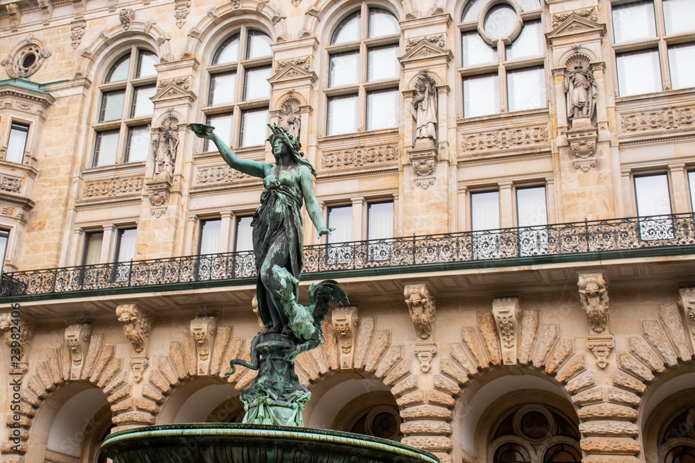 Detail of ornate statue of Woman in fountain with large  ancient building in background