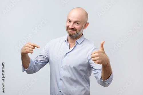 Man proud of himself over gray background. I am the best concept.