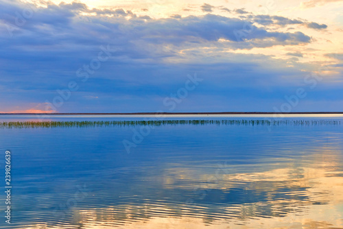 Beautiful landscape with the lake. Smooth lake surface after the sunset. © Yerbolat