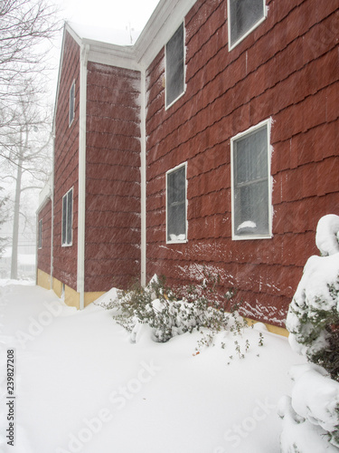 driveway of red house during the snow storm  photo