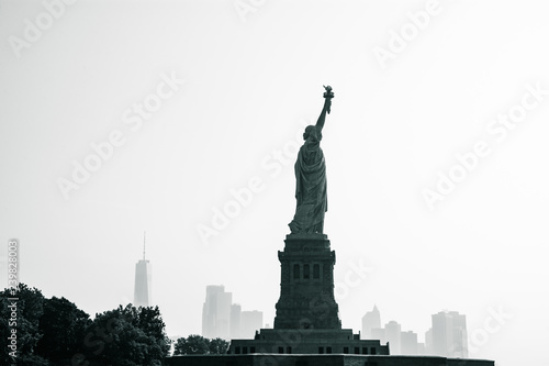 Liberty statue in New York City with skyline of the island of Manhattan