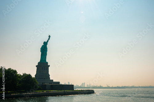 Liberty statue in New York City with skyline of the island of Manhattan