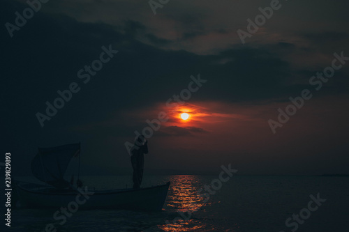 Fisherman collects fish in sunset © toghrul