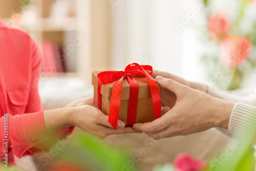 valentines day, greeting and people concept - close up of male and female hands with gift box