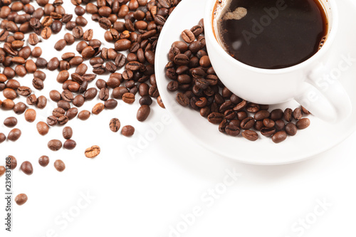 Cup of strong coffee in roasted coffee beans on white background, isolated