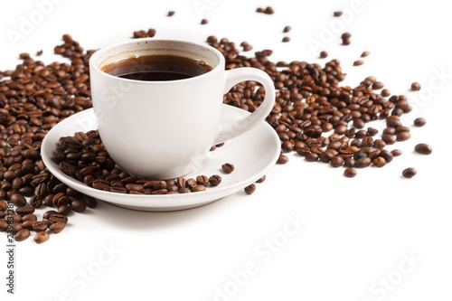 Cup of strong coffee in roasted coffee beans on white background, isolated