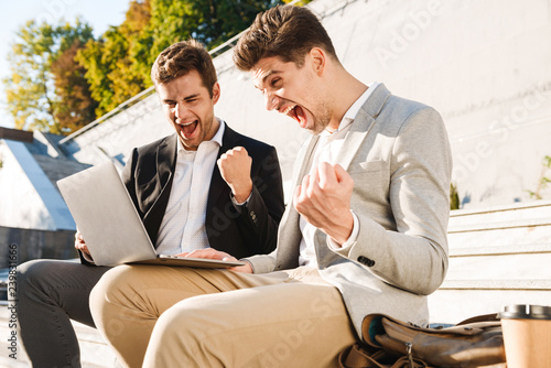 Two confident businessmen using laptop computer © Drobot Dean