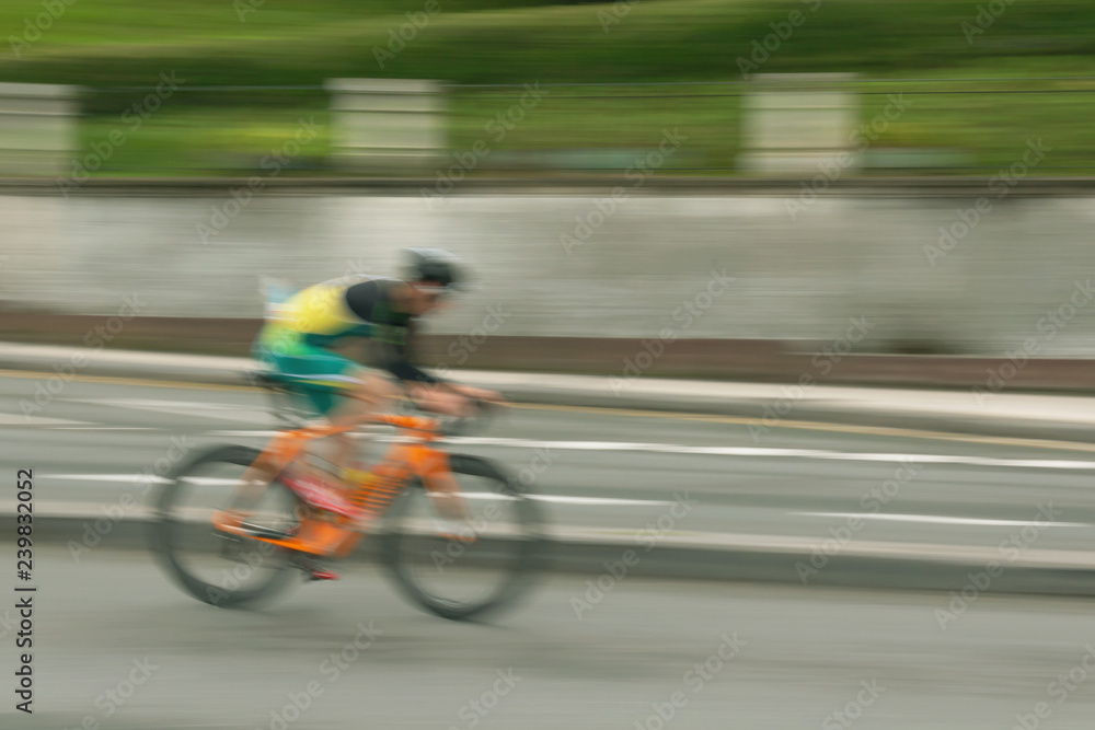 Blurred silhouette of bicyclist on a blurred city background