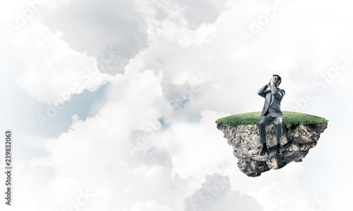 Young man on floating island in blue sky do not want to see anyt