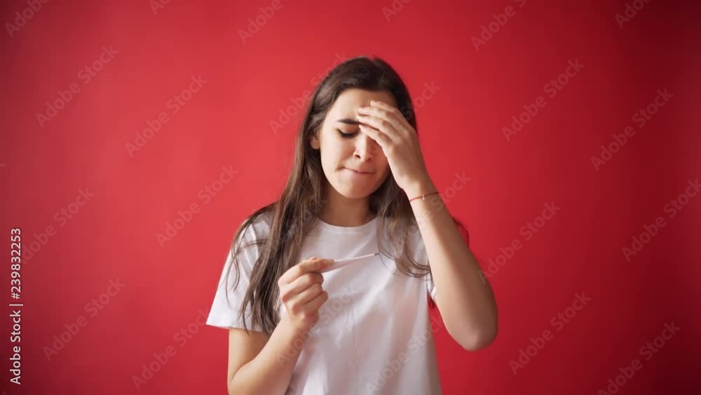 The concept of menses, ovulation in girls. Girl on a red background holding a tampon, gasket. The concept of menses, ovulation in girls. Girl on a red background holding a tampon, gasket.