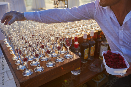 Cocktails with raspberry served on reseption by barmen photo