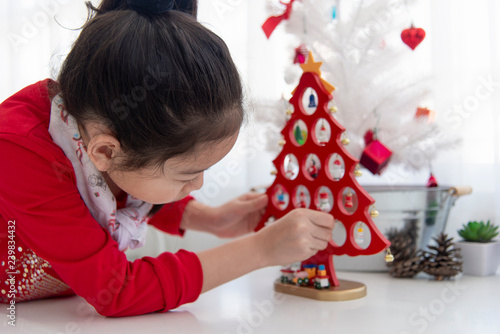 Christmas and new year theme young asian woman decorating Christmas tree..