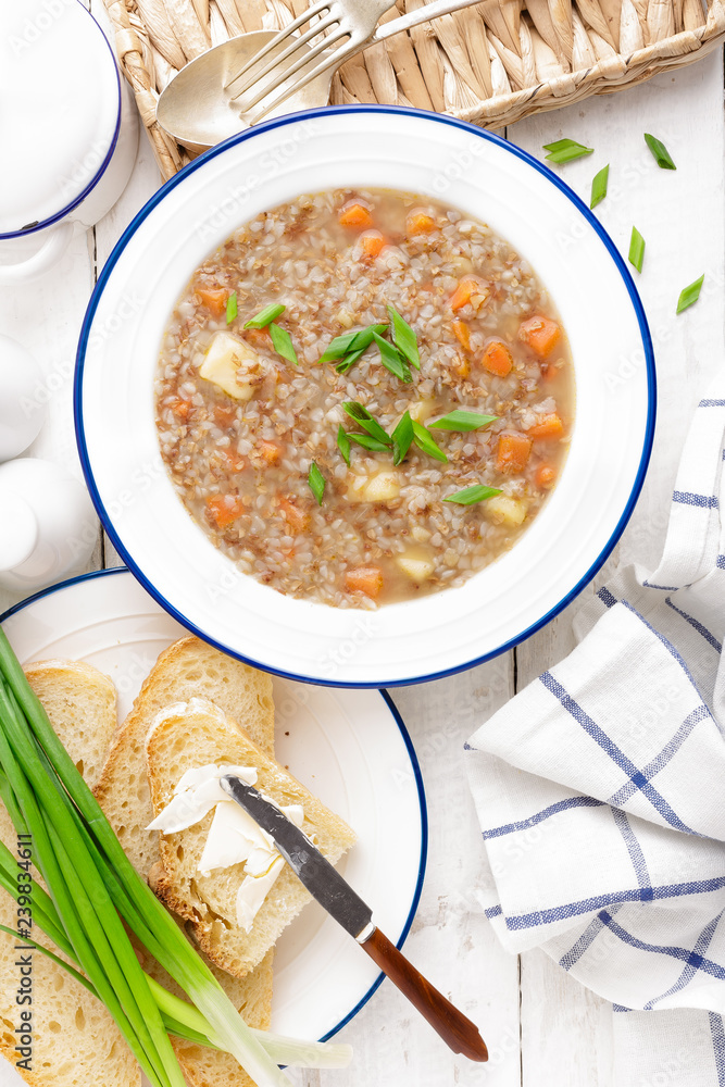 Buckwheat soup with carrot and potato on white wooden rustic table. Healthy vegetarian food, top view Buckwheat soup with carrot and potato on white wooden rustic table. Healthy vegetarian food, top view