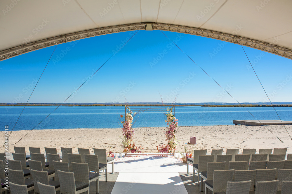 Obraz premium Event decoration. Wedding chuppa at riverside decorated with fresh flowers. Florist workflow